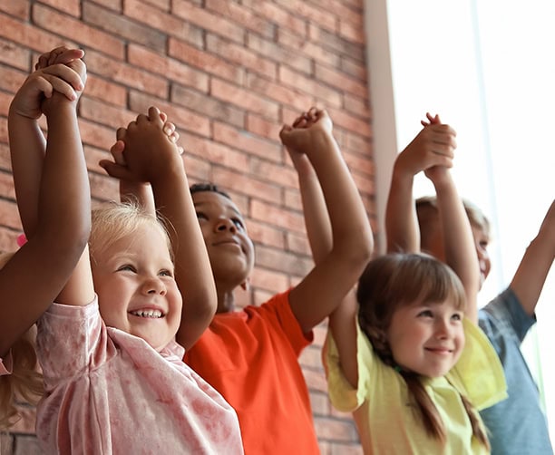 Diverse Children Raising Hands Classroom