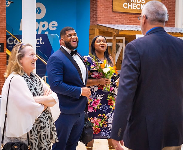 Church Members Greeting Couple In Lobby