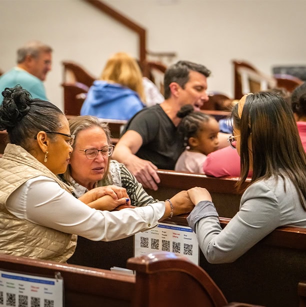Church Members Praying Together In Pews